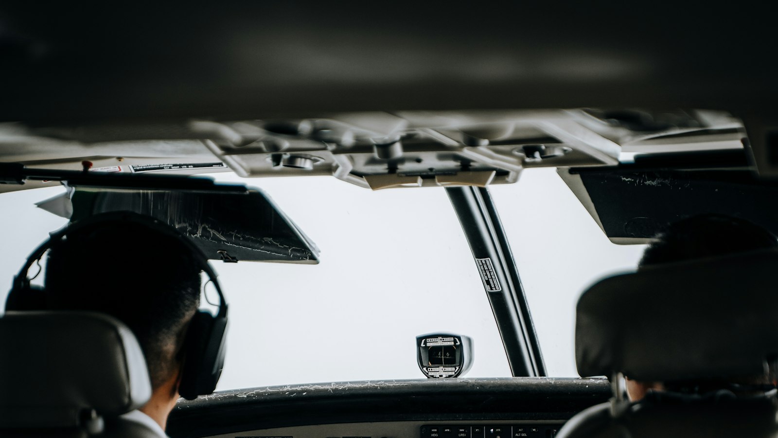 Pilot wearing a headset in an aircraft cockpit with a second seat beside