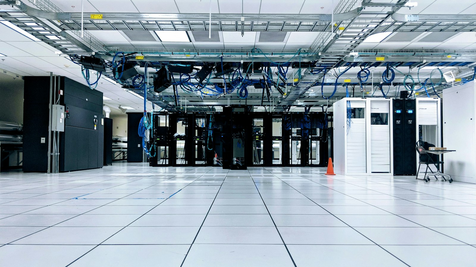 A server room with rows of network cabinets and cables overhead